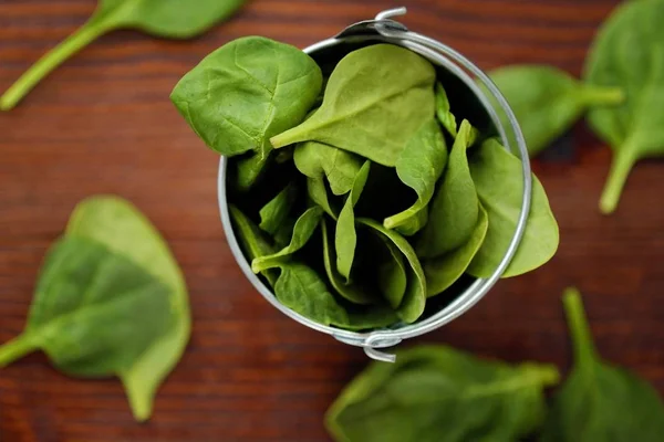 Delicious fresh spinach in a little bucket on the table — Stock Photo, Image