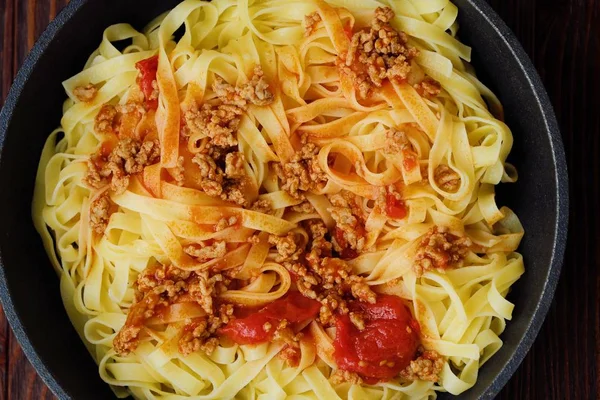 Delicious tagliatelle pasta with mince and tomatoes in a frying pan — Stock Photo, Image