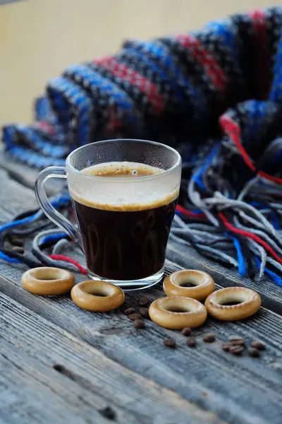 Вкусный освежающий кофе и бублики на деревянном столе — стоковое фото