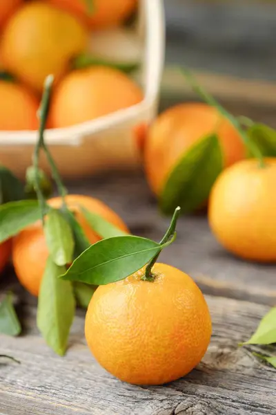 Verse, smakelijke mandarijnen met bladeren op houten tafel — Stockfoto