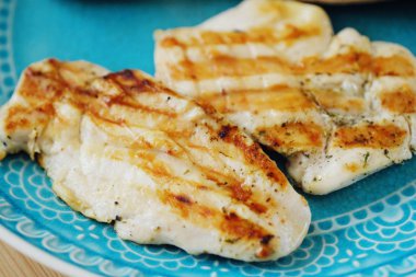 Mavi bir tabak içinde taze tavuk fileto ızgara