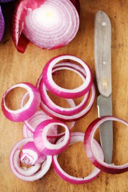 Kırmızı taze soğan ve bıçağı masanın üzerine