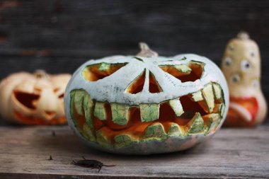 Ahşap masada korkunç Cadılar Bayramı balkabakları. Yaklaş.