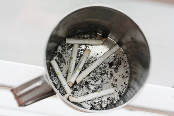 鉄のマグカップに灰を入れたタバコの吸い殻 — ストック写真