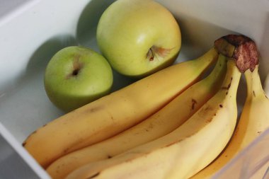Dolapta taze muz ve elma var.