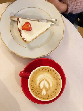 Kafede çilekli bir dilim pasta.