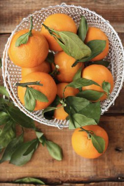 Masada yaprakları olan taze, sulu mandalinalar 