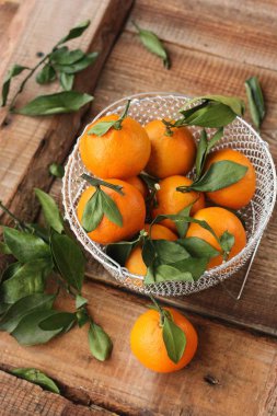 Masada yaprakları olan taze, sulu mandalinalar 