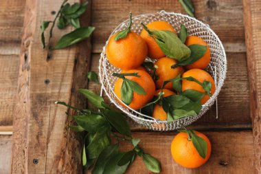 Masada yaprakları olan taze, sulu mandalinalar 