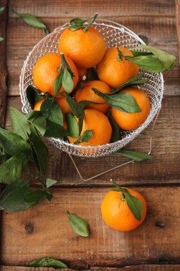 Masada yaprakları olan taze, sulu mandalinalar 