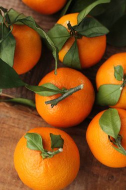 Masada yaprakları olan taze, sulu mandalinalar