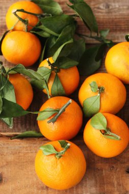 Masada yaprakları olan taze, sulu mandalinalar