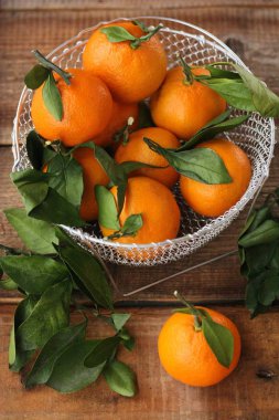 Masada yaprakları olan taze, sulu mandalinalar