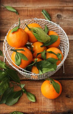 Masada yaprakları olan taze, sulu mandalinalar