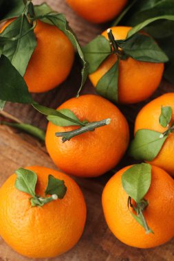 Masada yaprakları olan taze, sulu mandalinalar
