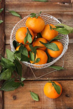 Masada yaprakları olan taze, sulu mandalinalar