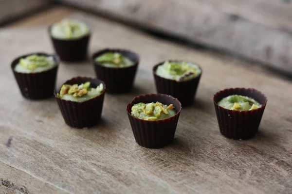 Delicious chocolate candies with pistachios on the table