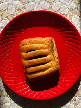 Kırmızı tabakta kiraz reçelli lezzetli turta.