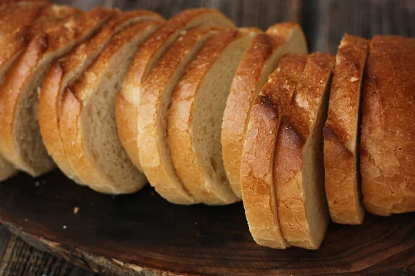 美味的新鲜面包放在木制桌子上 — 图库照片