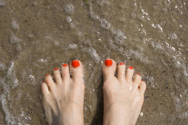 Patas femeninas en una playa de arena. Primer plano — Foto de Stock