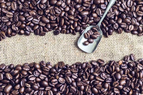 Zevkle görüntülenen kahve çekirdekleri ve bir gümüş kaşık