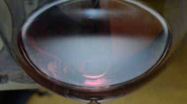 Japanese yen in transparency behind a glass of wine