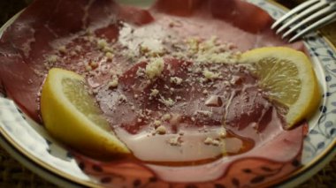 Limon suyu, zeytinyağı ve parmesan peynirli Bresaola dilimleri..