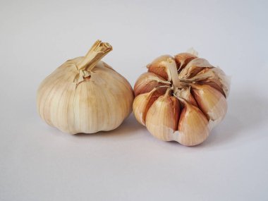 Beyaz bir arka plan üzerinde iki sarımsak ampul.