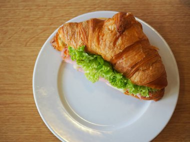 Ahşap masa üzerinde sandviç kruvasan