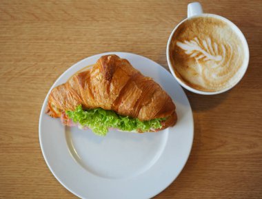 Bir fincan kahve ve kruvasan peynir sandviç