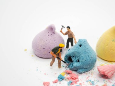 Minyatür işçi ve beyaz arka plan, sele üzerinde renkli merengue