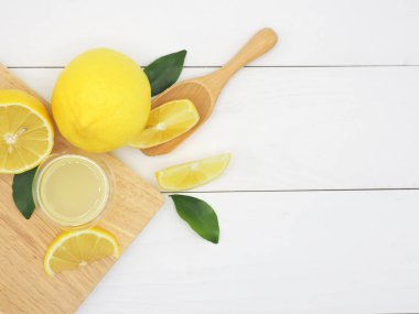 Bir küçük kase ve limon dilim Beyaz ahşap üzerine taze limon suyu 