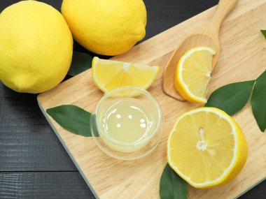 Küçük kase ve koyu ahşap bac üzerinde limon dilim taze limon suyu