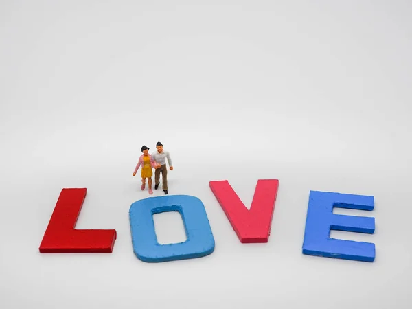 Amante casal em miniatura com letras de palavras de amor no backgroun branco — Fotografia de Stock