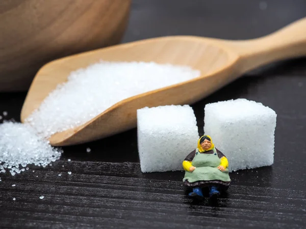 Mulher gorda miniatura de pé perto de tigela de madeira e colher com sug — Fotografia de Stock