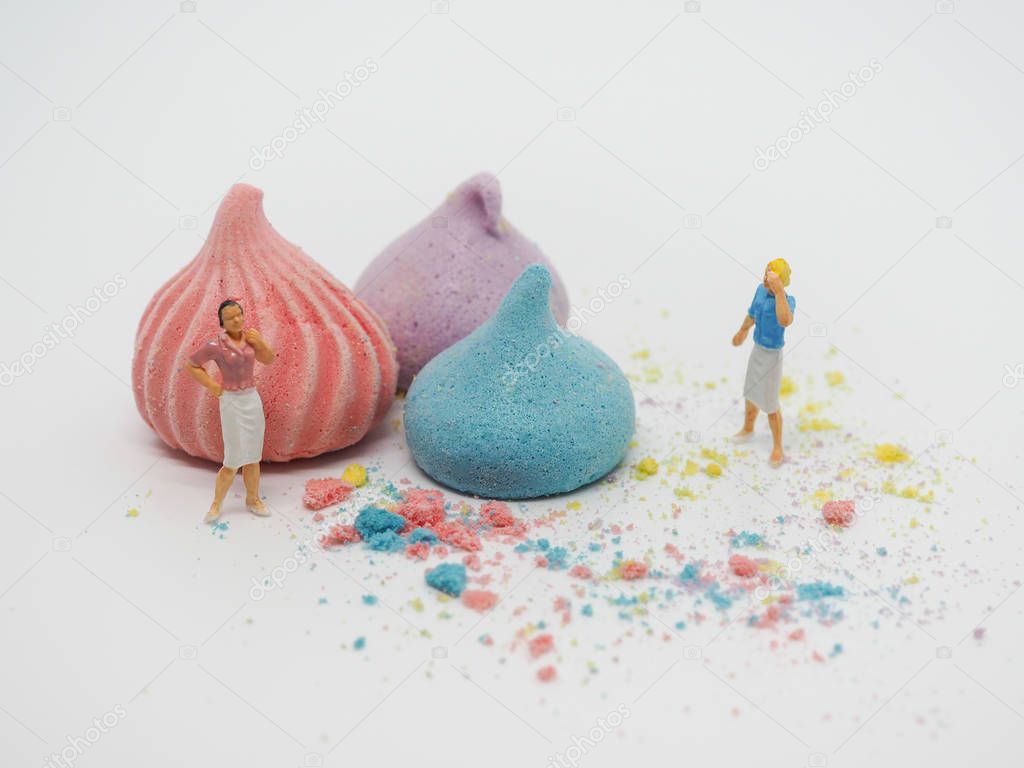 Miniature woman standing near sweets and thinking of sugar, diet