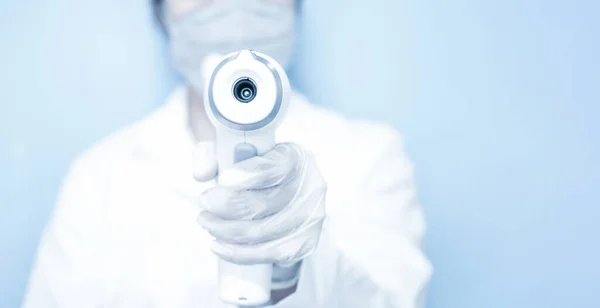 Lekarz Noszący Maskę Trzymający Medyczny Termometr Czole Podczerwieni Celu Sprawdzenia — Zdjęcie stockowe