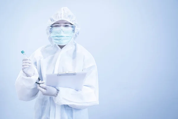 Asian doctor in personal protective suit with a test tube, mask and patient chart, work hard without depression in crisis of covid-19. Medical and healthcare concept.