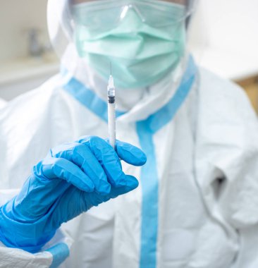 Kişisel koruyucu giysili kadın doktor, koronavirüs enfeksiyonu riskine karşı bağışıklık kazandırmak için aşı aşısı hazırlayın. Coronavirus, covid-19, tıbbi ve aşı konsepti.
