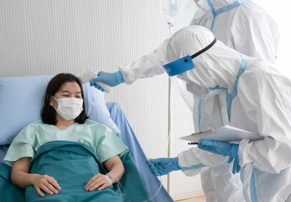 Två Läkare Bära Ppe Kostym Med Ansiktsmask Mäta Kroppstemperaturen Hos Stockbild