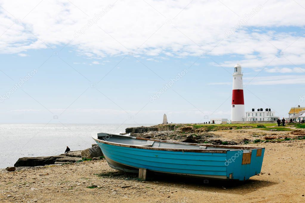 Seaside, boat and lighthouse in Portland, Dorset, UK