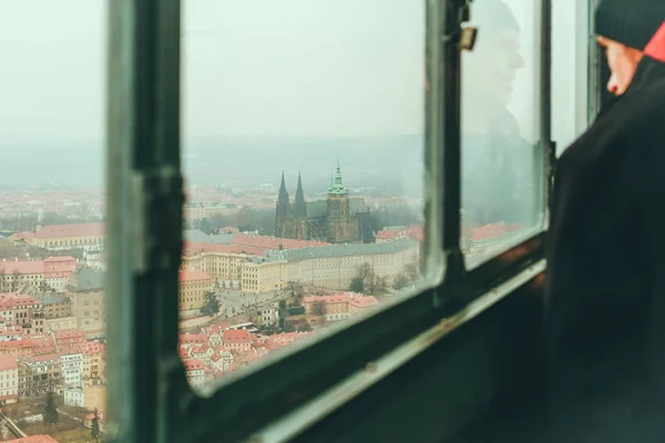 Человек, смотрящий на Прагу из окна смотровой площадки — стоковое фото