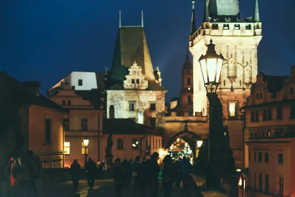 Lidé chodí na Karlově mostě, Praha v noci — Stock fotografie