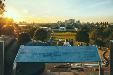 Gün batımı ve çekici fotoğraf Greenwich Park, Londra, tepenin üstüne oturan seyreden.