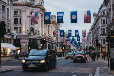 Siyah taksi ve Regent Street, Londra araçlarda Nfl ve Union Jack bayrakları altında 