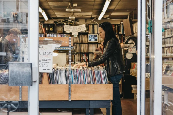 Notting Hill, Londra bir mağazada kadın Gözat vinil kayıtlar. — Stok fotoğraf