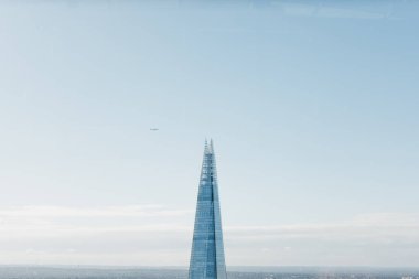 Plane flying over Shard, the highest building in London.  clipart