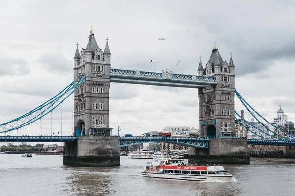 河游船船、 旅游巴士和一架飞机在伦敦塔桥旁边. — 图库照片