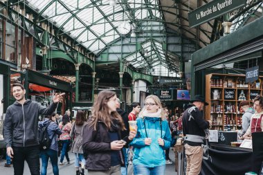 Women walk inside Borough Market, London clipart