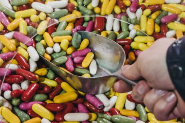 El çok renkli jöle fasulye toplama bir kepçe ile